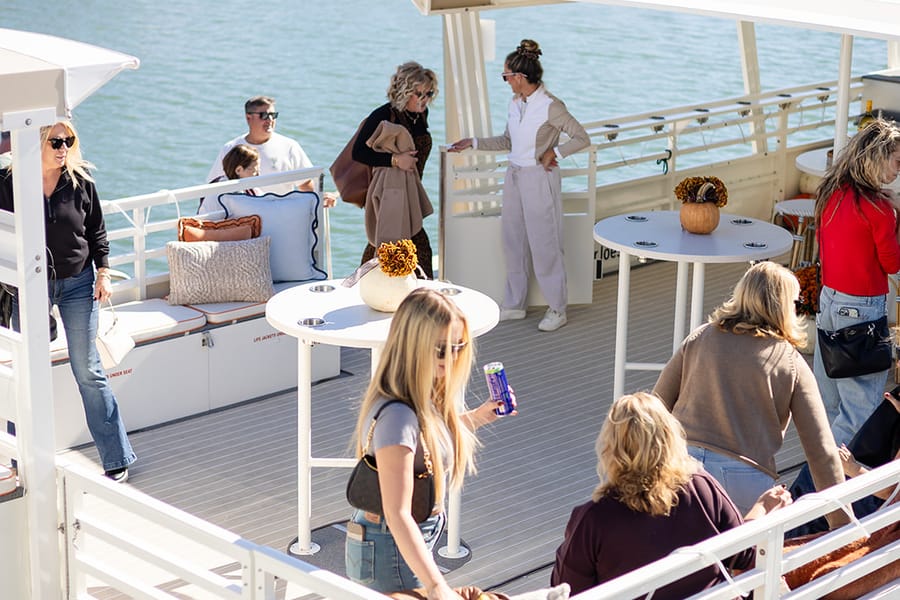 A group of guests mingling on the deck of The Sandbar Social at the dock